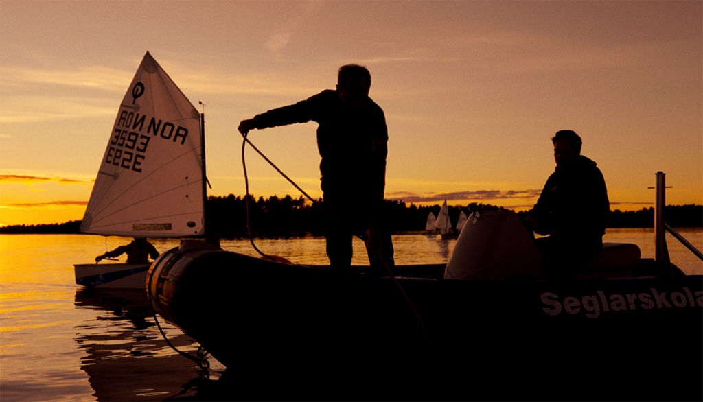 Motorbåt och segelbåt i solnedgång.