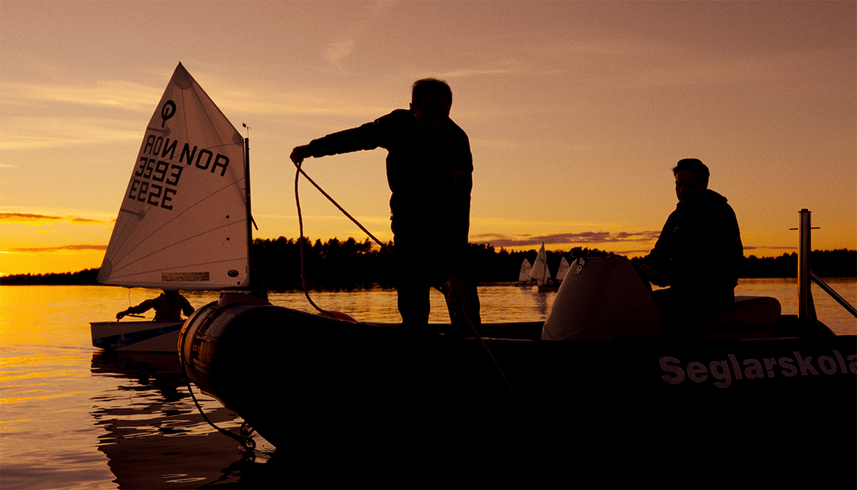 Motorbåt och segelbåt i solnedgång