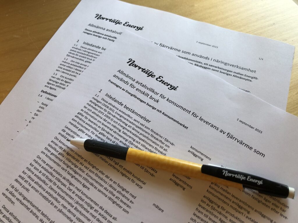 Två papper med text och en penna.