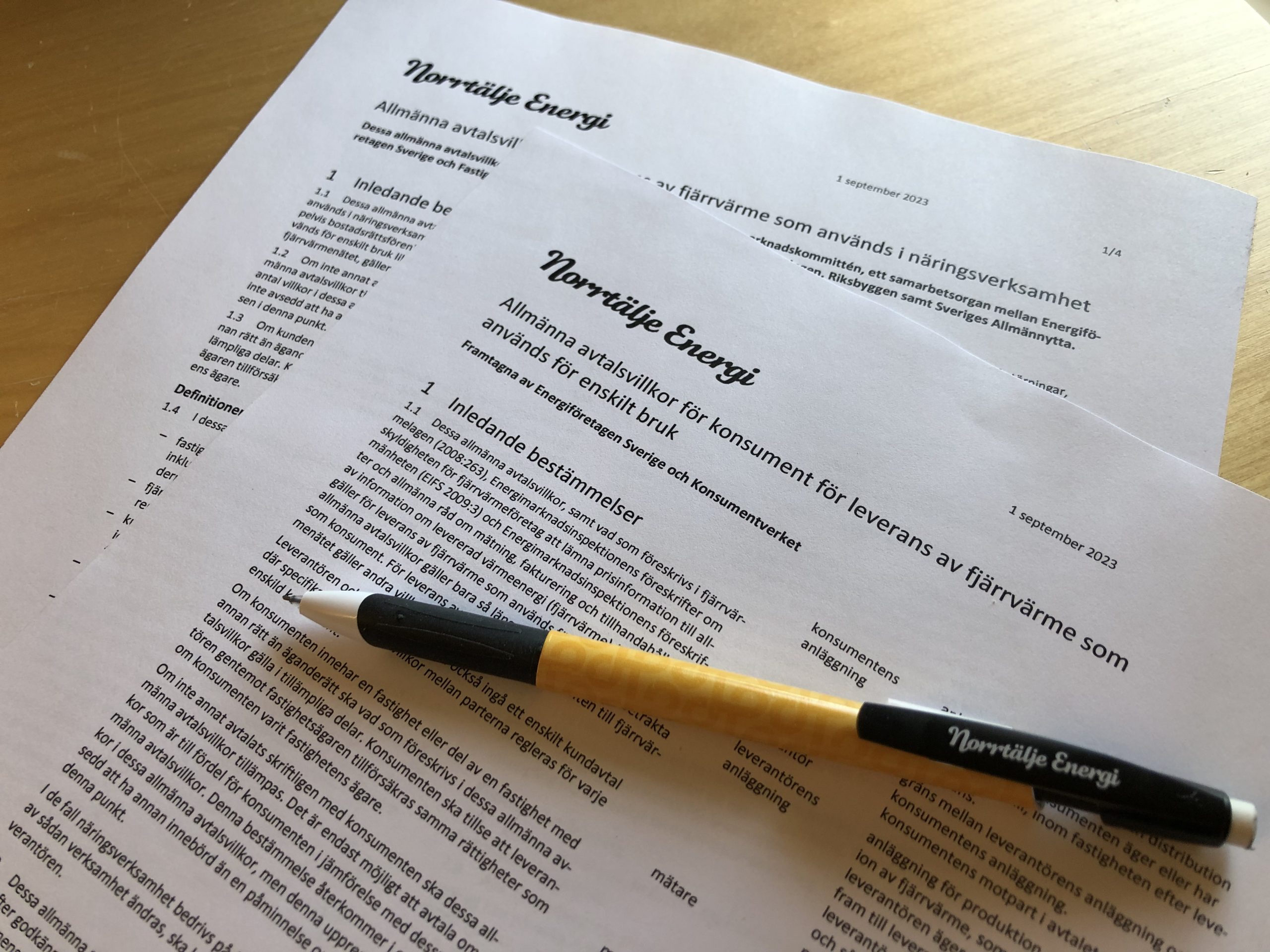 Två papper med text och en penna