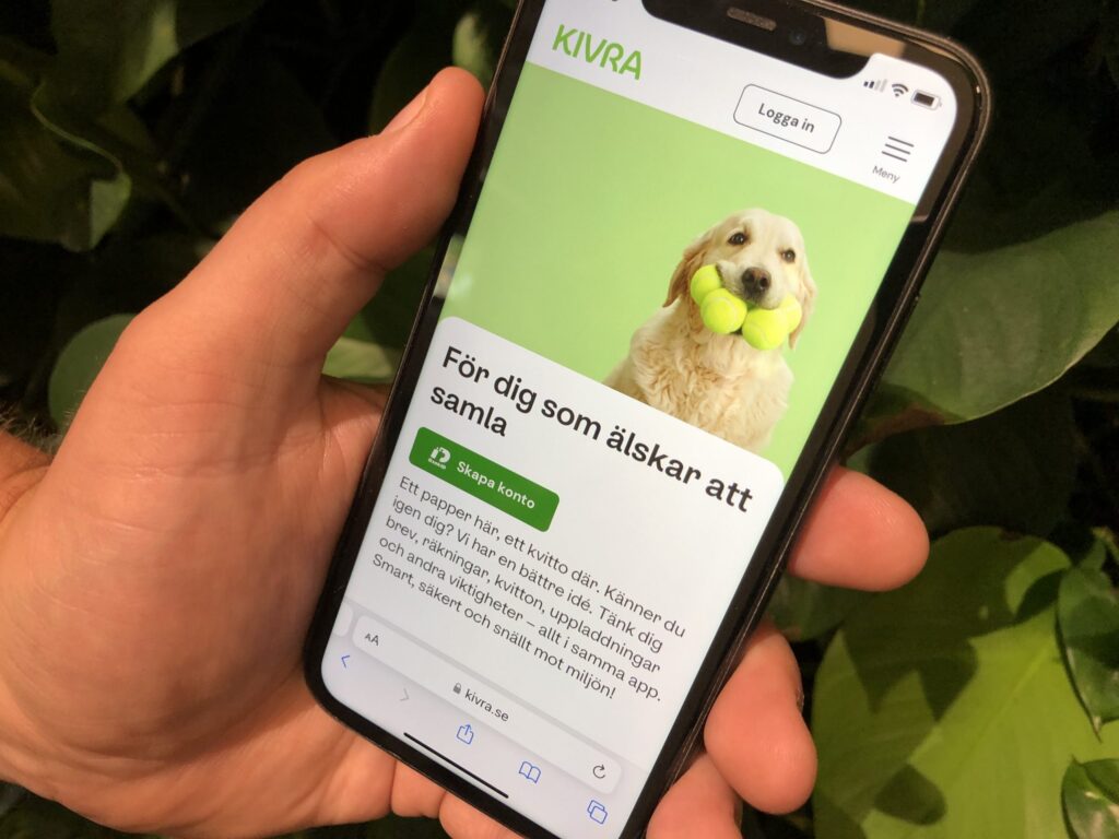 En hand med en mobiltelefon i.