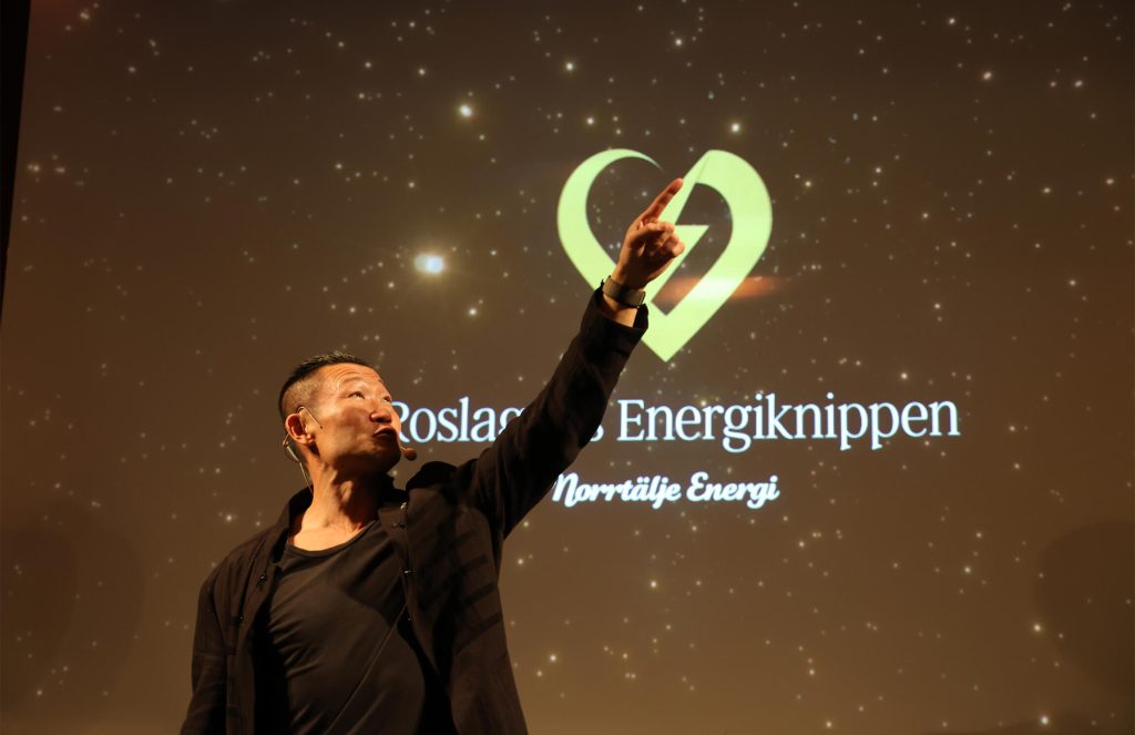 Energiknippegalan 2023, en talare set upp emot taket och pekar med ena handen och fingret upp mot taket och himmelen.