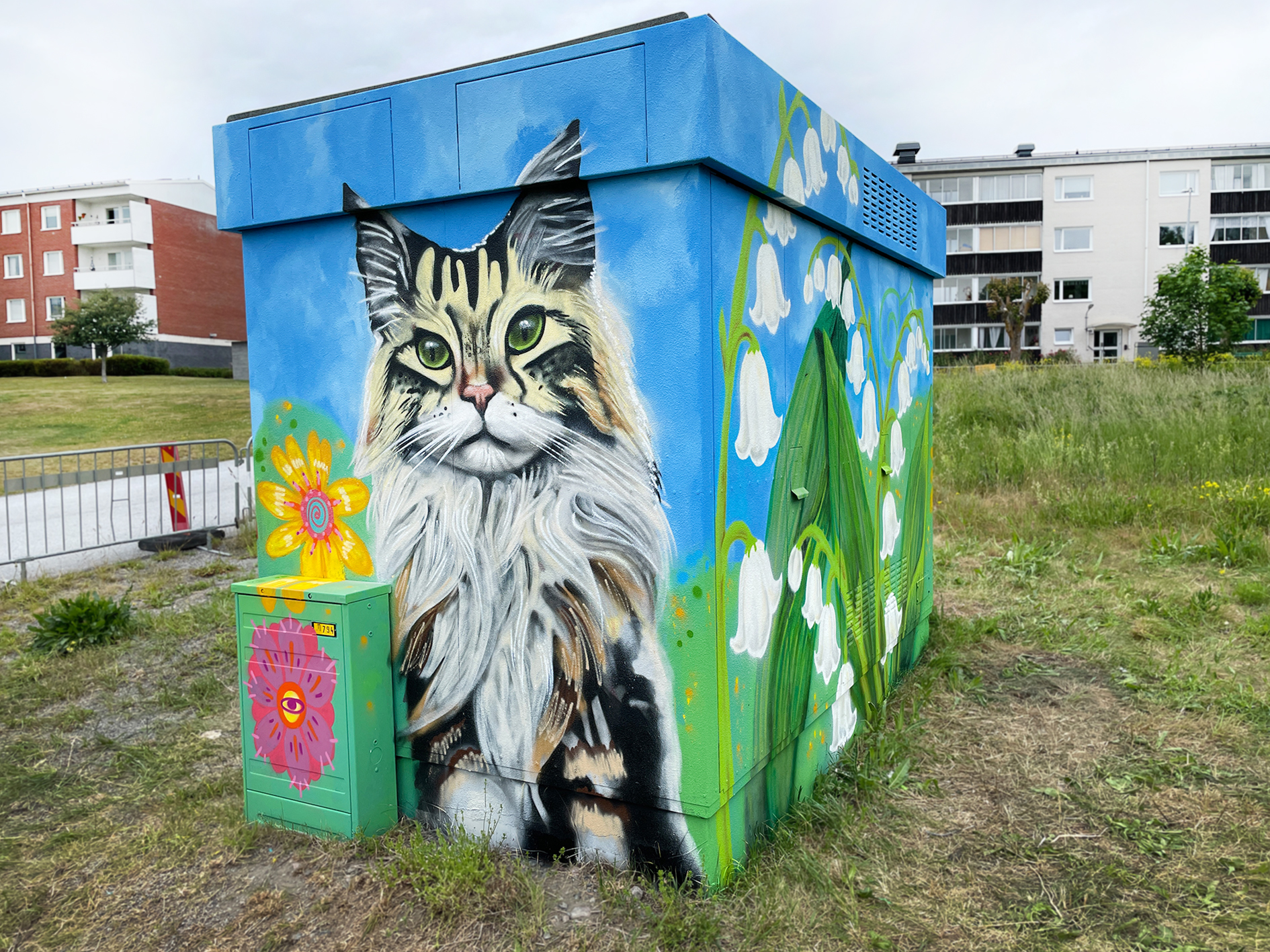 Målning på en nätstation (litet hus) föreställande en ljus katt.