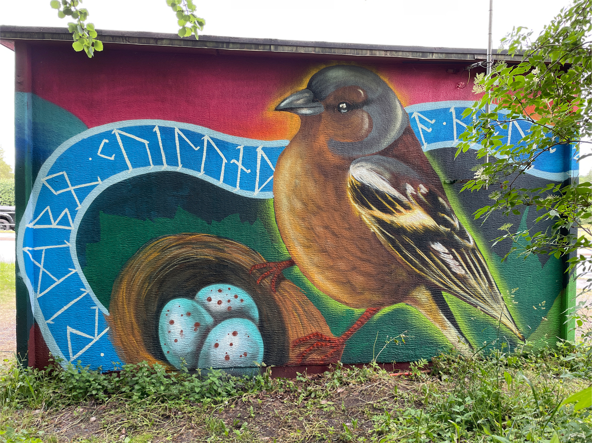  Mural av en fågel vid sitt bo med ägg, omgiven av färgstarka former.