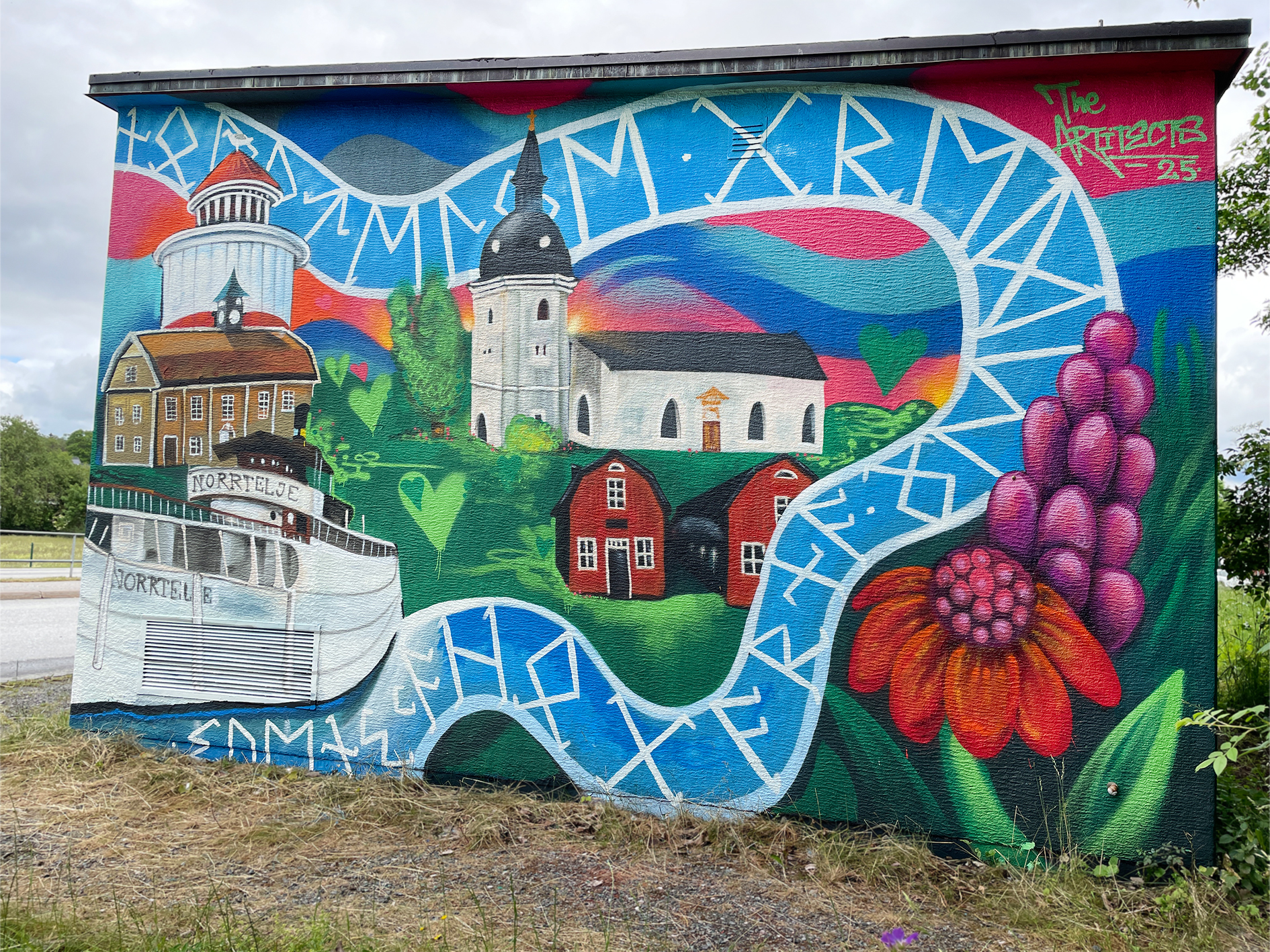 Mural med Norrtäljes byggnader, kyrka och färgglad bakgrund.
