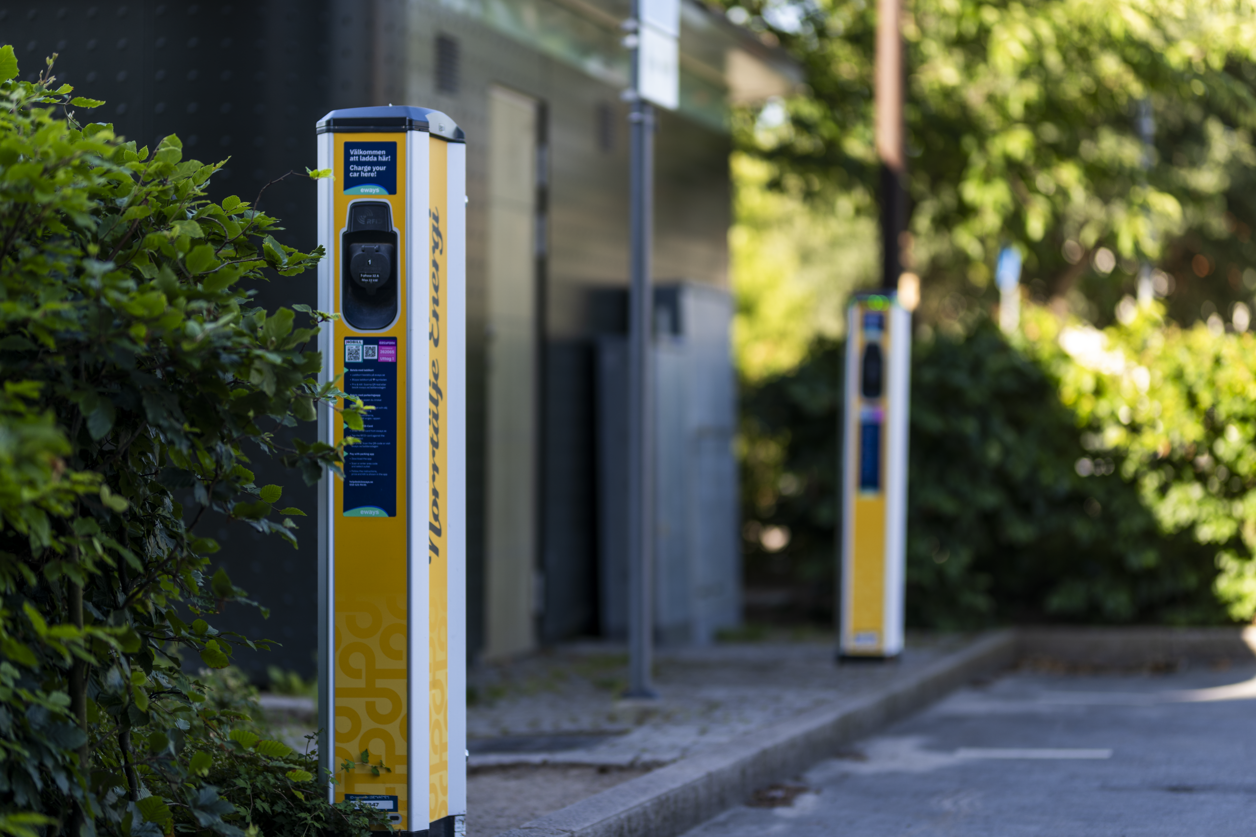 Elbilsladdare med laddstolpar i förgrunden.